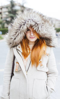 Porträt einer jungen Frau mit orange gefärbtem Haar und Kapuzenjacke im Herbst - LJF01144