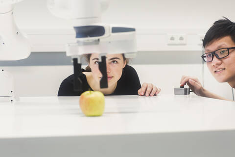 Sudents studying robotic at an university institute, making experiments with an apple stock photo