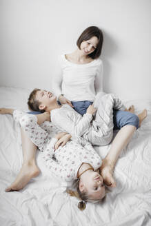 Mutter hat Spaß mit zwei Kindern im Bett - EYAF00768