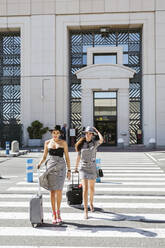 Zwei modische junge Frauen mit Gepäck auf dem Flughafen - LJF01188
