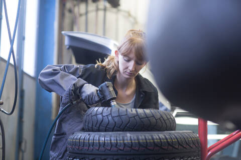 Automechanikerin bei der Arbeit in einer Reparaturwerkstatt, lizenzfreies Stockfoto