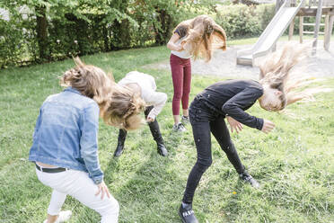 Four girls shaking their heads covered with dandelion seeds - STBF00510