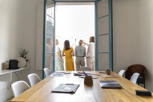 Rückansicht von vier Frauen, die auf dem Balkon vor dem Konferenzraum stehen - AFVF04489