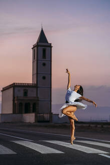 Ballerina tanzt vor einer Kirche am Abend - MPPF00415