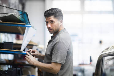 Junger Mann bei der Arbeit in einer Polsterei - SGF02545