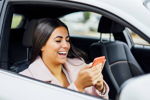 Geschäftsfrau benutzt Smartphone im Auto, lizenzfreies Stockfoto