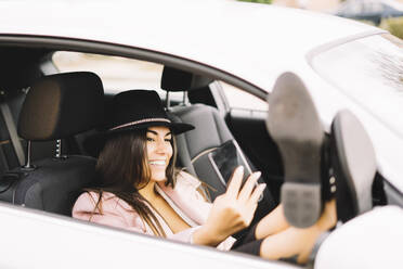 Geschäftsfrau benutzt Smartphone und macht ein Selfie im Auto - CJMF00208