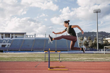 Female hurdler during training on tartan track - LJF01196