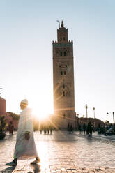 Spaziergänger auf dem Fußweg vor der Koutoubia-Moschee bei Sonnenuntergang - CAVF70776