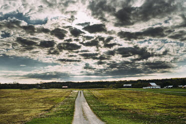 Scenic view of country road against cloudy sky - CAVF70807