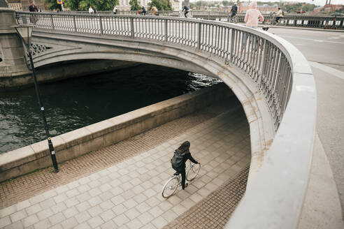 Hohe Winkel Ansicht der Geschäftsfrau Radfahren auf dem Gehweg am Kanal in der Stadt - MASF15569