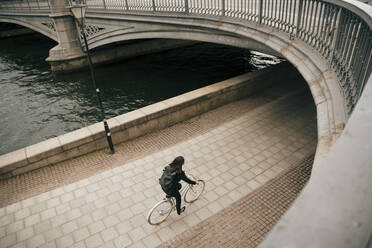 Hohe Winkel Ansicht der Geschäftsfrau Radfahren auf dem Gehweg am Kanal in der Stadt - MASF15571