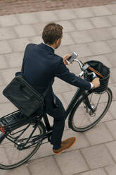 Hohe Winkel Ansicht der Geschäftsmann Fahrrad fahren auf dem Gehweg in der Stadt - MASF15575