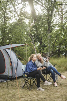 Frau in voller Länge im Gespräch mit ihrer Tochter auf dem Campingplatz - MASF15638