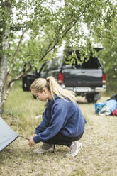Teenager-Mädchen beim Zeltaufbau auf einem Campingplatz - MASF15657