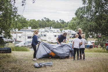 Kinder helfen den Eltern beim Aufbau des Zeltes auf dem Campingplatz - MASF15668