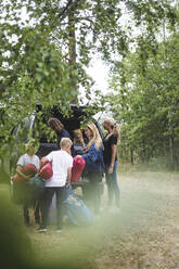 Familie beim Ausladen des Gepäcks aus dem Auto auf dem Campingplatz - MASF15681