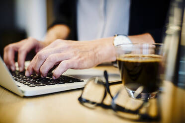 Mittelteil eines reifen Anwalts mit Laptop am Schreibtisch im Büro - MASF15764