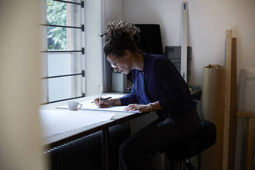 Seitenansicht einer selbstbewussten Architektin bei der Arbeit im Büro - MASF15961