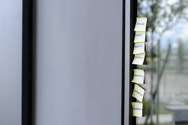 Adhesive notes on glass wall in office - BMOF00097