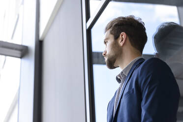 Junger Geschäftsmann lehnt sich gegen das Fenster - BMOF00103