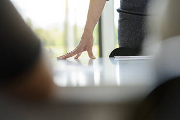 Close-up of businesswoman leaning on desk in office - BMOF00115