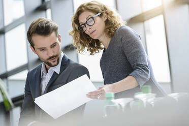 Businesswoman with colleague checking documents in office - BMOF00119