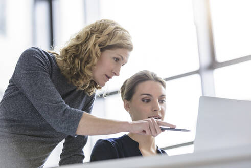 Zwei Frauen arbeiten an einem Laptop im Büro - BMOF00135