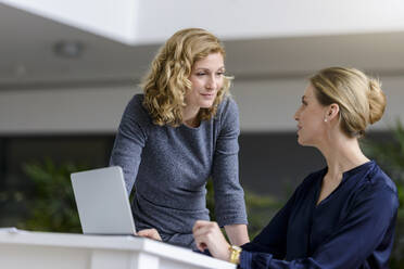 Zwei Frauen sprechen am Schreibtisch im Büro - BMOF00138