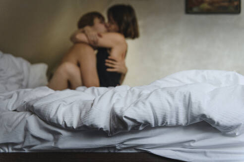 Paar umarmt und küsst sich auf dem Bett - EYAF00783