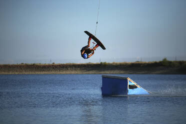 Kiteboarder beim Stunt auf dem Kicker im See - CAVF71019