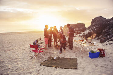 Fröhliche Freunde beim Zelten am Strand bei Sonnenuntergang - CAVF71077