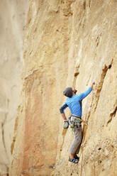 Männlicher Bergsteiger, der beim Bergsteigen nach oben schaut - CAVF71123