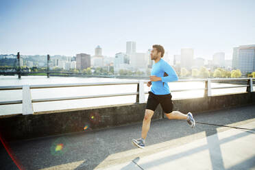 Man running on footpath against clear sky - CAVF71139