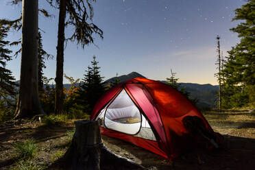 Beleuchtetes Zelt auf einem Feld gegen den Himmel in der Abenddämmerung - CAVF71233