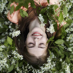 Overhead view of woman lying amidst plants - CAVF71251