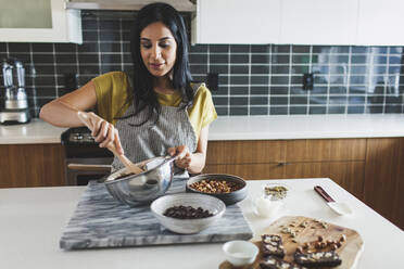 Woman making chocolate sauce in kitchen - CAVF71306