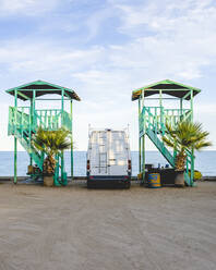 Wohnmobil geparkt bei Rettungsschwimmerhütten am Strand gegen den Himmel - CAVF71325