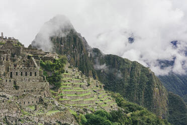 Panoramablick auf Machu Picchu mit dem Berg Huayna Picchu bei nebligem Wetter - CAVF71334