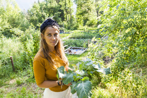 Frau bei der Gartenarbeit, Kind im Sandkasten - TCF06240