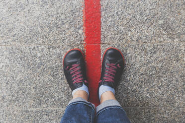 Germany, Hamburg, Two feet standing on a red line marking Hummel Bummel tourist route - IHF00201