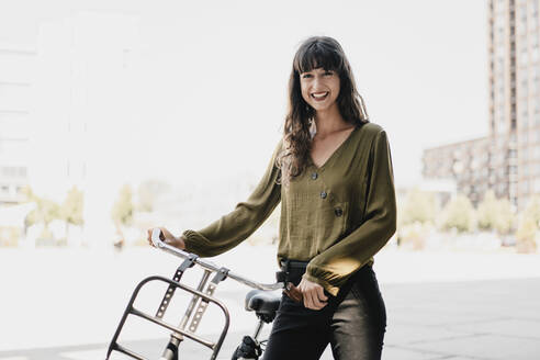 Smiling brunette woman with dutch roadster - KNSF06969