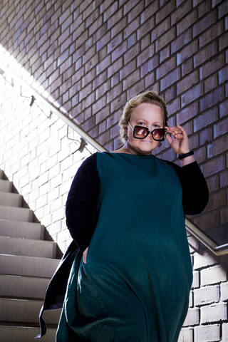 Eine kurvige Frau auf einer Treppe, lizenzfreies Stockfoto