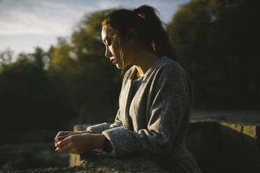 Ein Filmporträt einer jungen schönen Frau vor einem See - CAVF71344