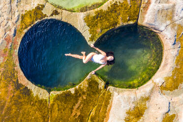 Luftaufnahme einer attraktiven Frau, die in einem Achterbecken im Royal National Park in Sydney, Australien, schwimmt. - AAEF06102