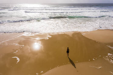 Luftaufnahme einer Frau, die allein am versteckten Strand von Alexandria Bay, Australien, spazieren geht. - AAEF06129