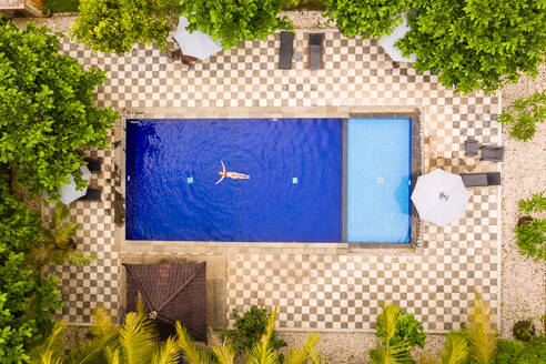 Aerial view of attractive girl floating over water at resort, Bali, Indonesia. - AAEF06194