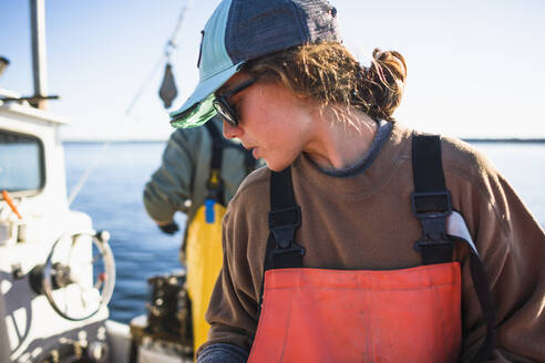 Frau arbeitet auf einem Muschelfischerboot in der Narragansett Bay - CAVF71477