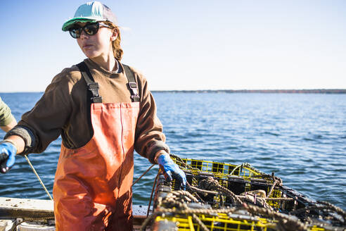 Frau arbeitet auf einem Muschelfischerboot in der Narragansett Bay - CAVF71488