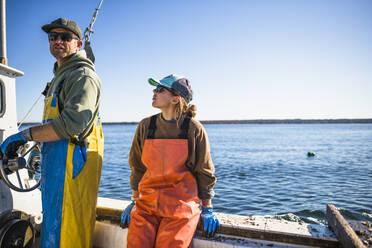 Frau und Mann bei der Arbeit auf einem Boot zum Muschelfischen in der Narragansett Bay - CAVF71492